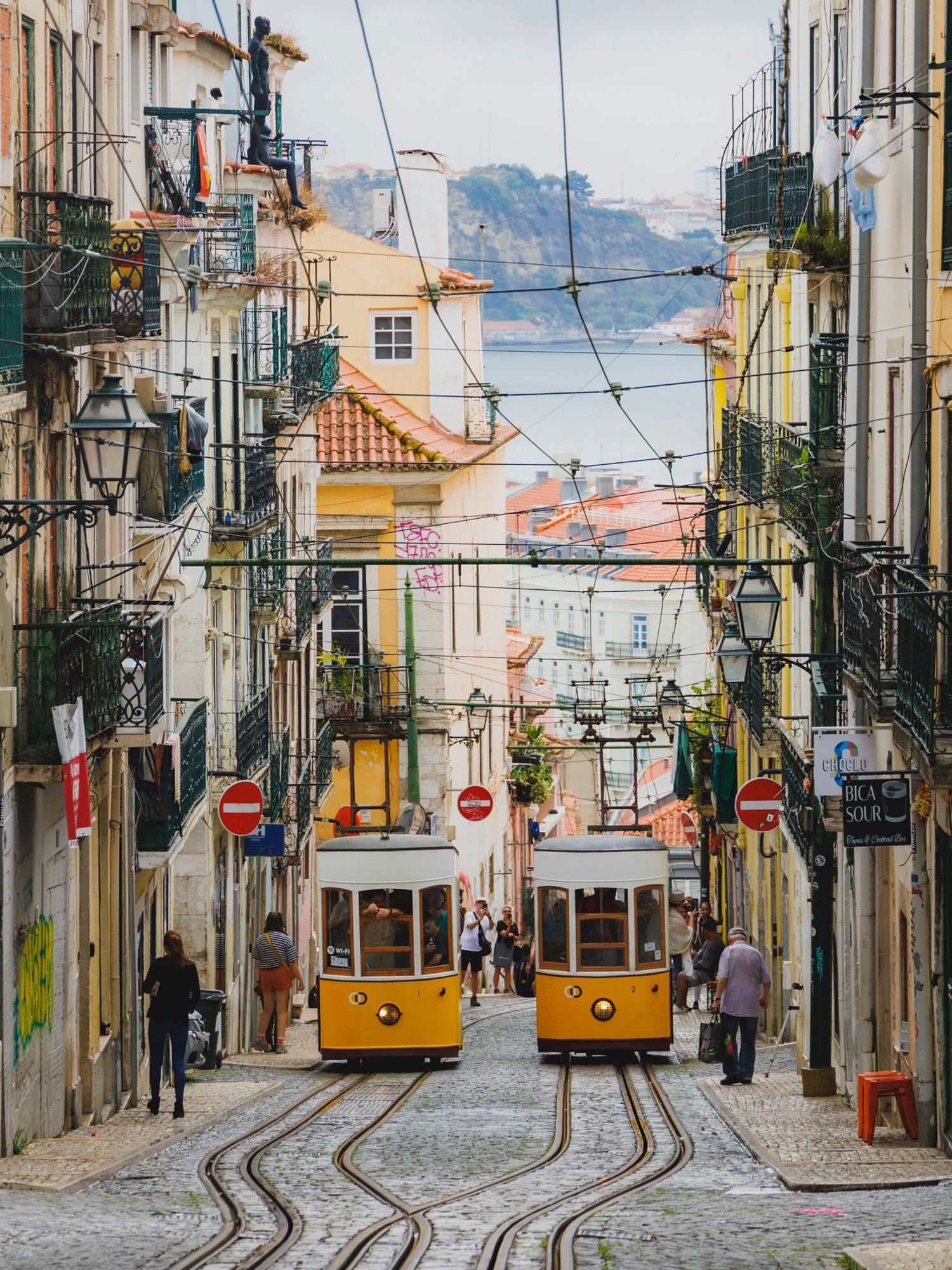 Yellow vintage tram on a steep street in Lisbon