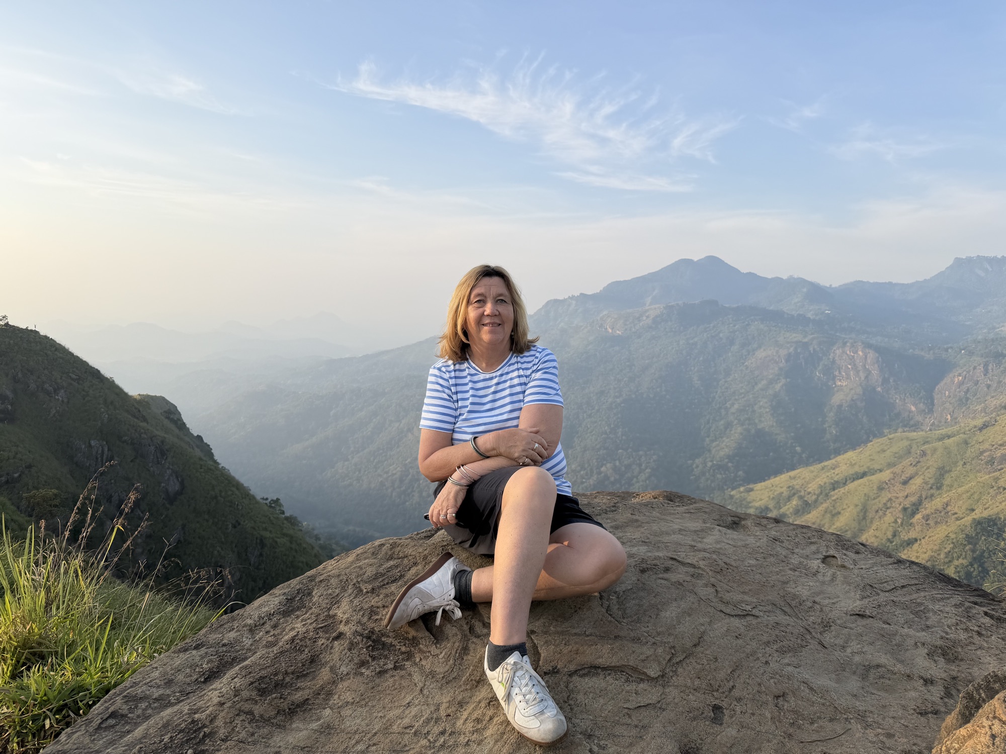 Judy sitting on a mountain lookout