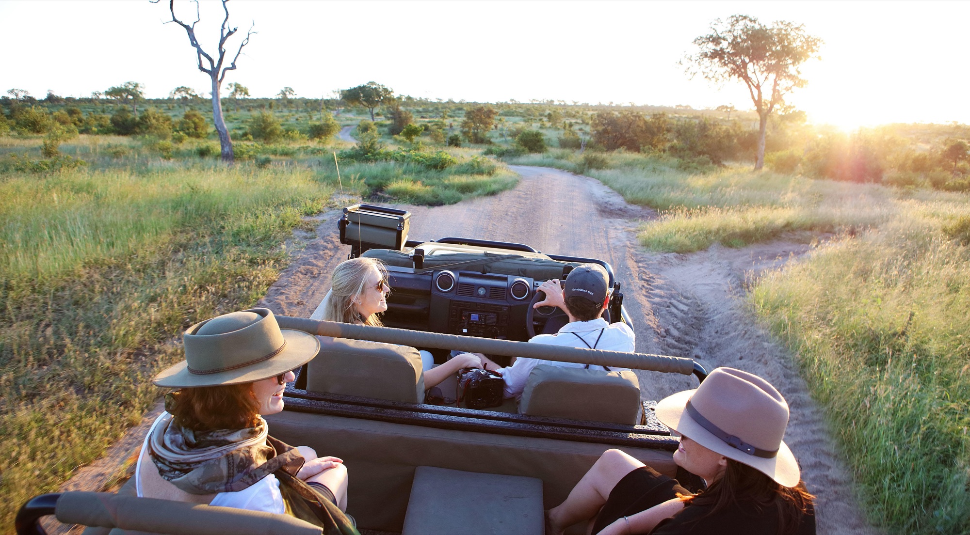 Family on an open safari vehicle at sunrise