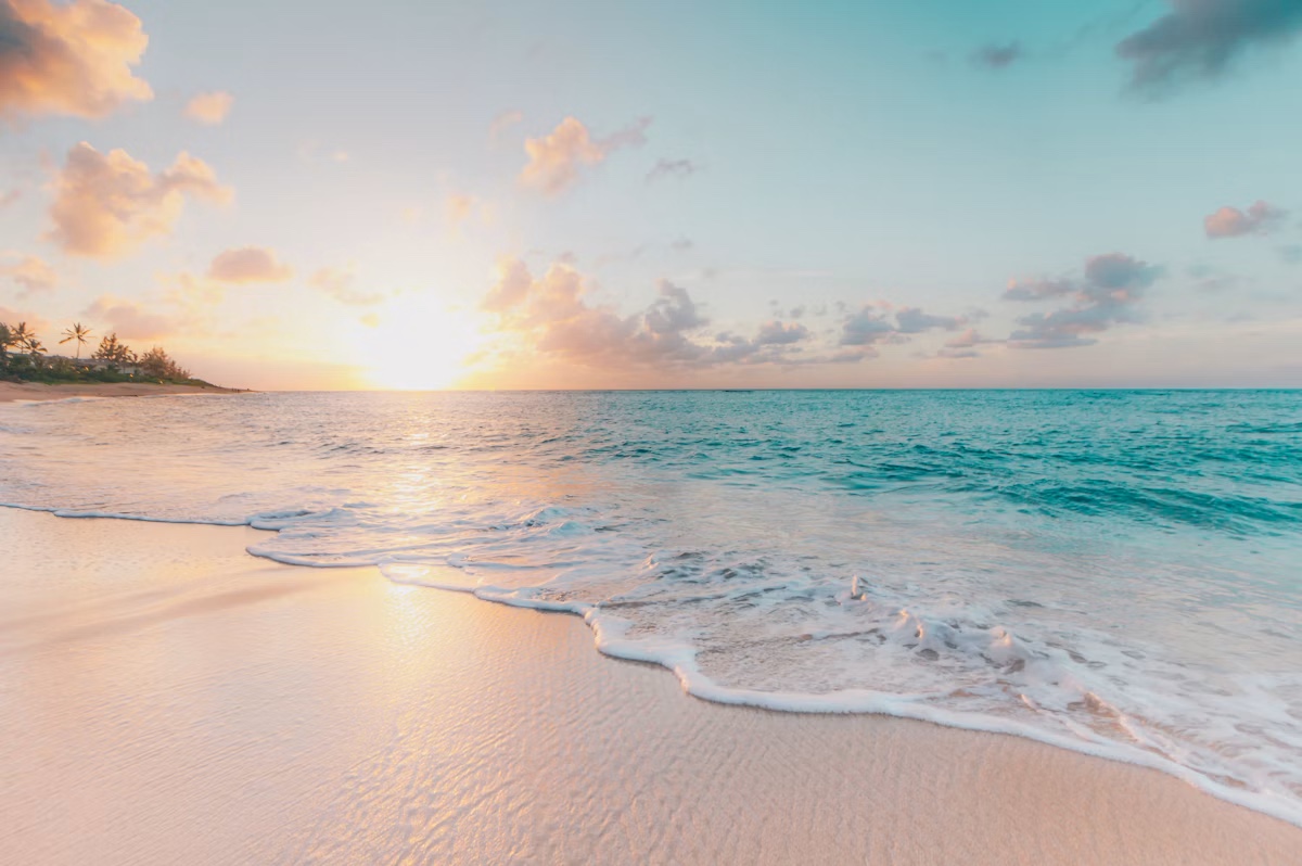 Soft waves on a white-sand beach at sunrise