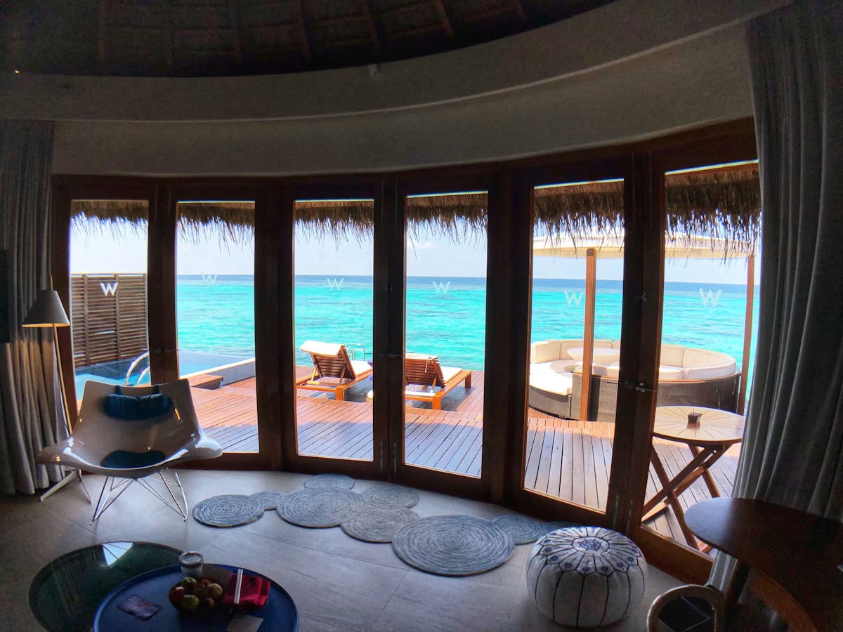 Inside an overwater villa looking out over the deck to the lagoon