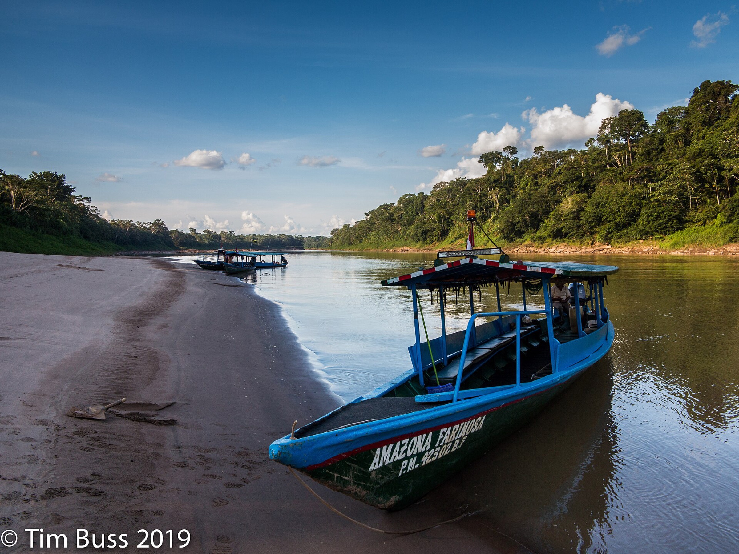 A wooden riverboat moored on a sandy bank in the Amazon