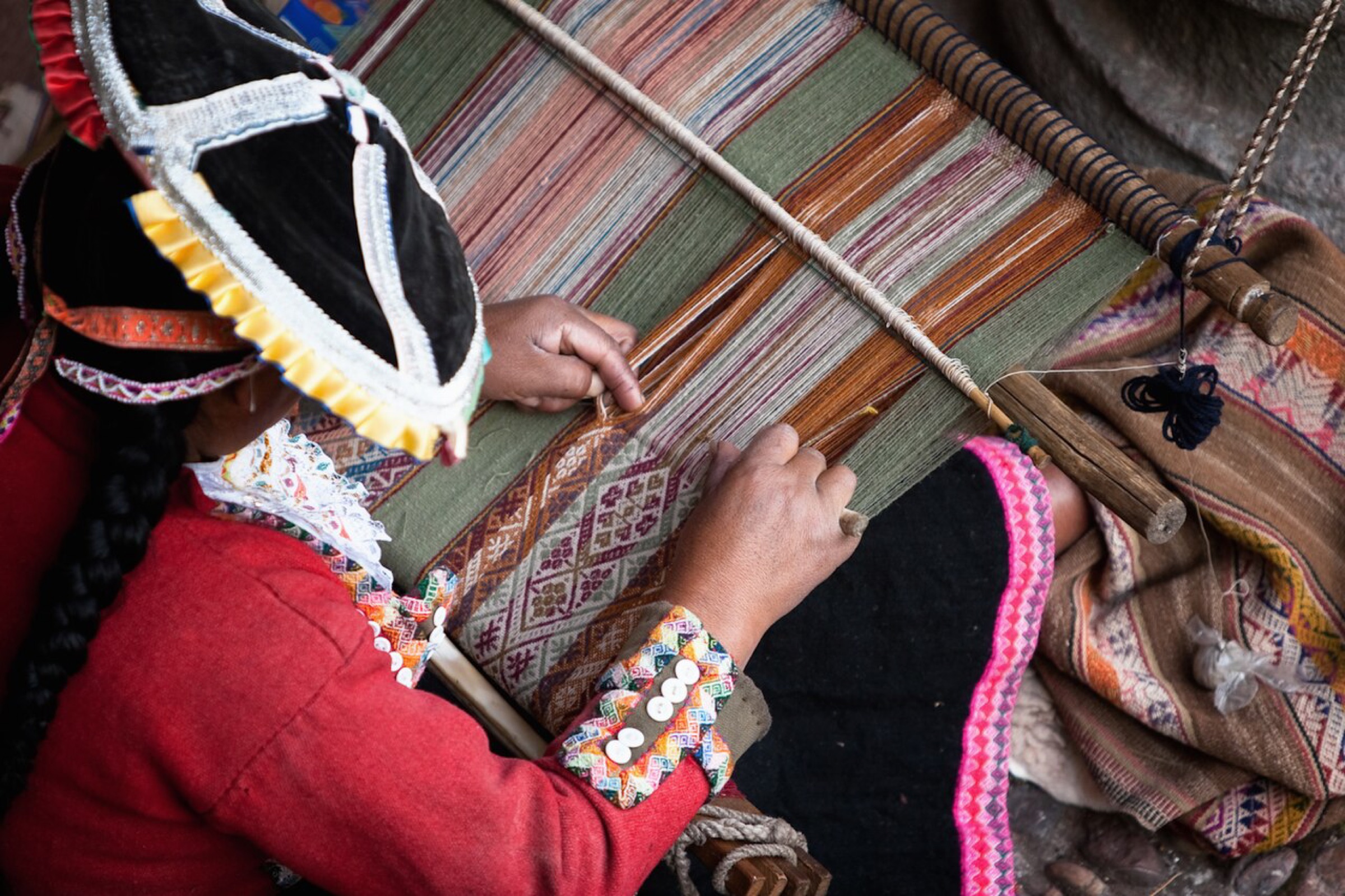 A weaver working at a traditional backstrap loom