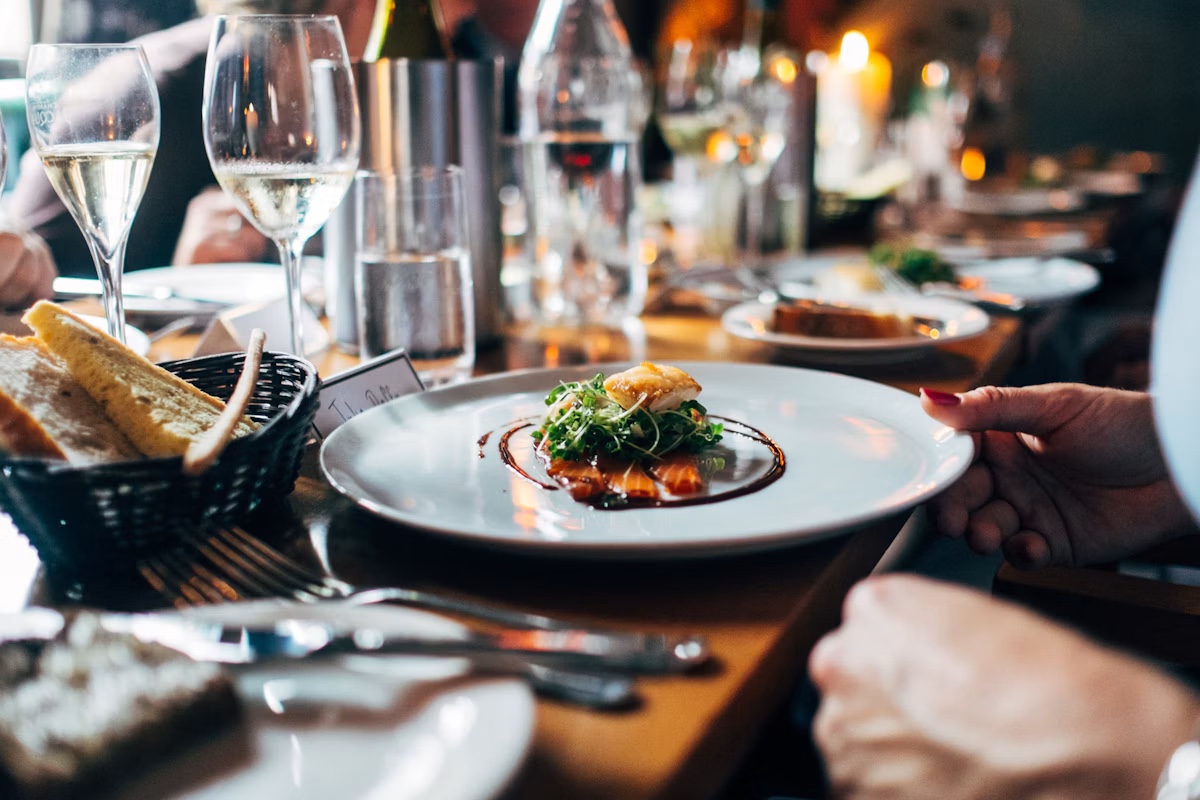 Plates and glasses on a long table at a fine-dining dinner