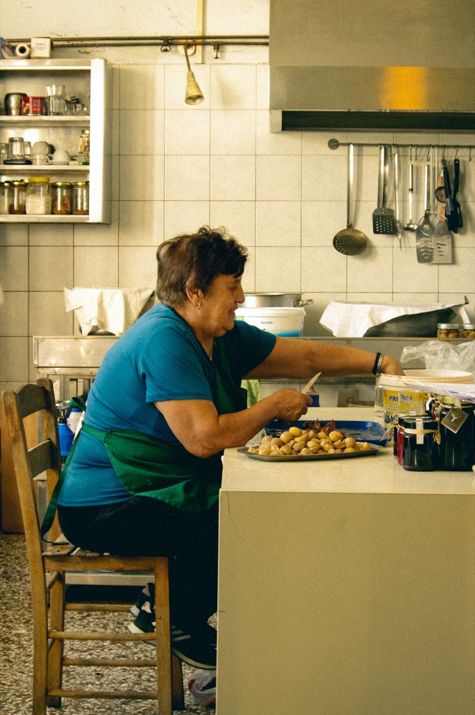 A Cretan cook preparing dishes in a traditional kitchen