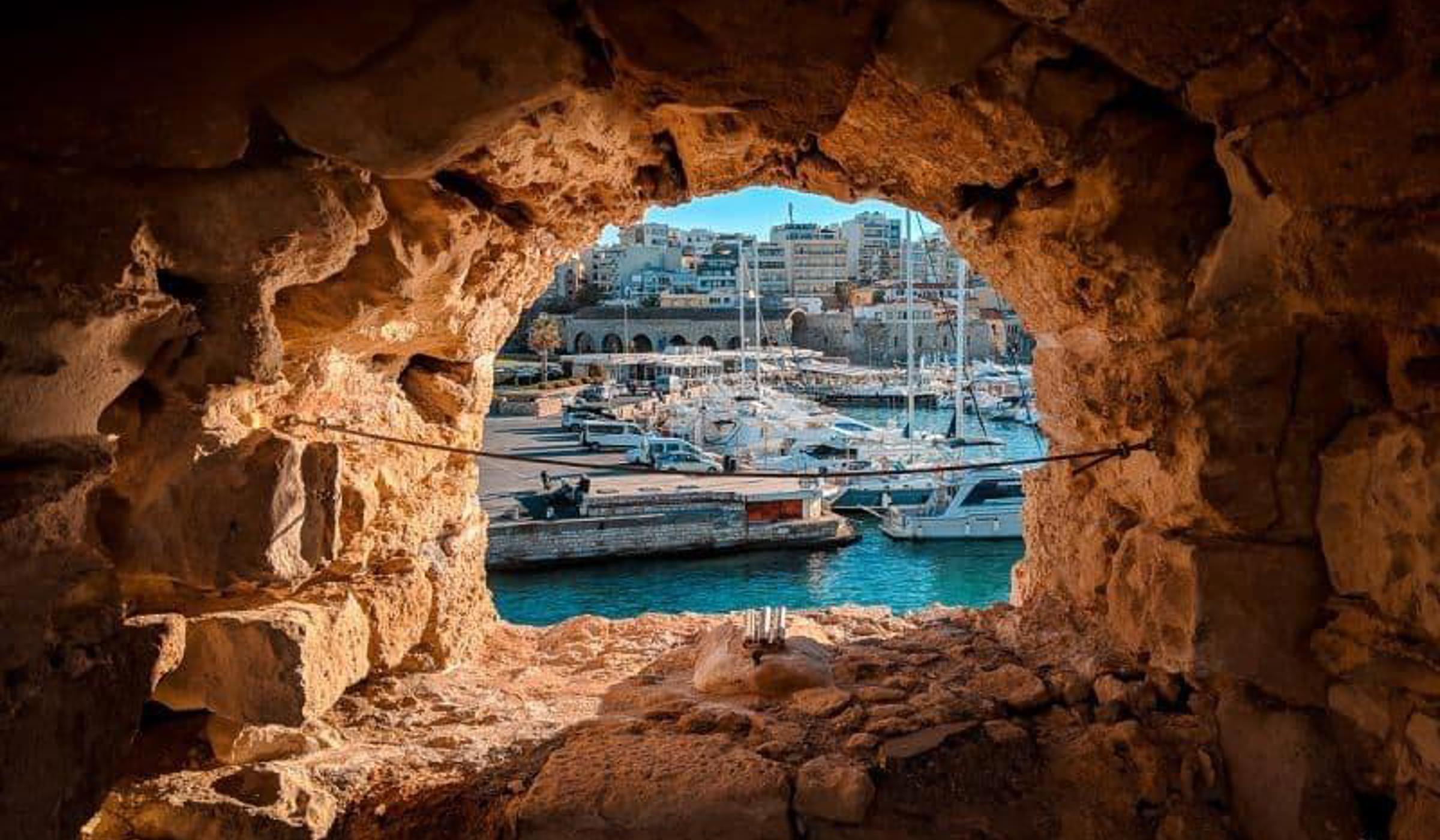 A Cretan harbour framed by a stone archway