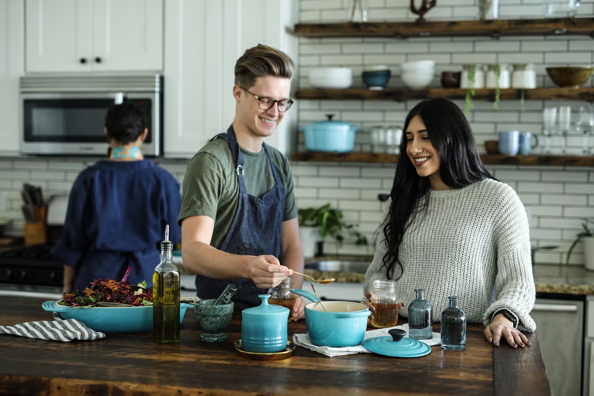 A couple cooking together in a bright kitchen
