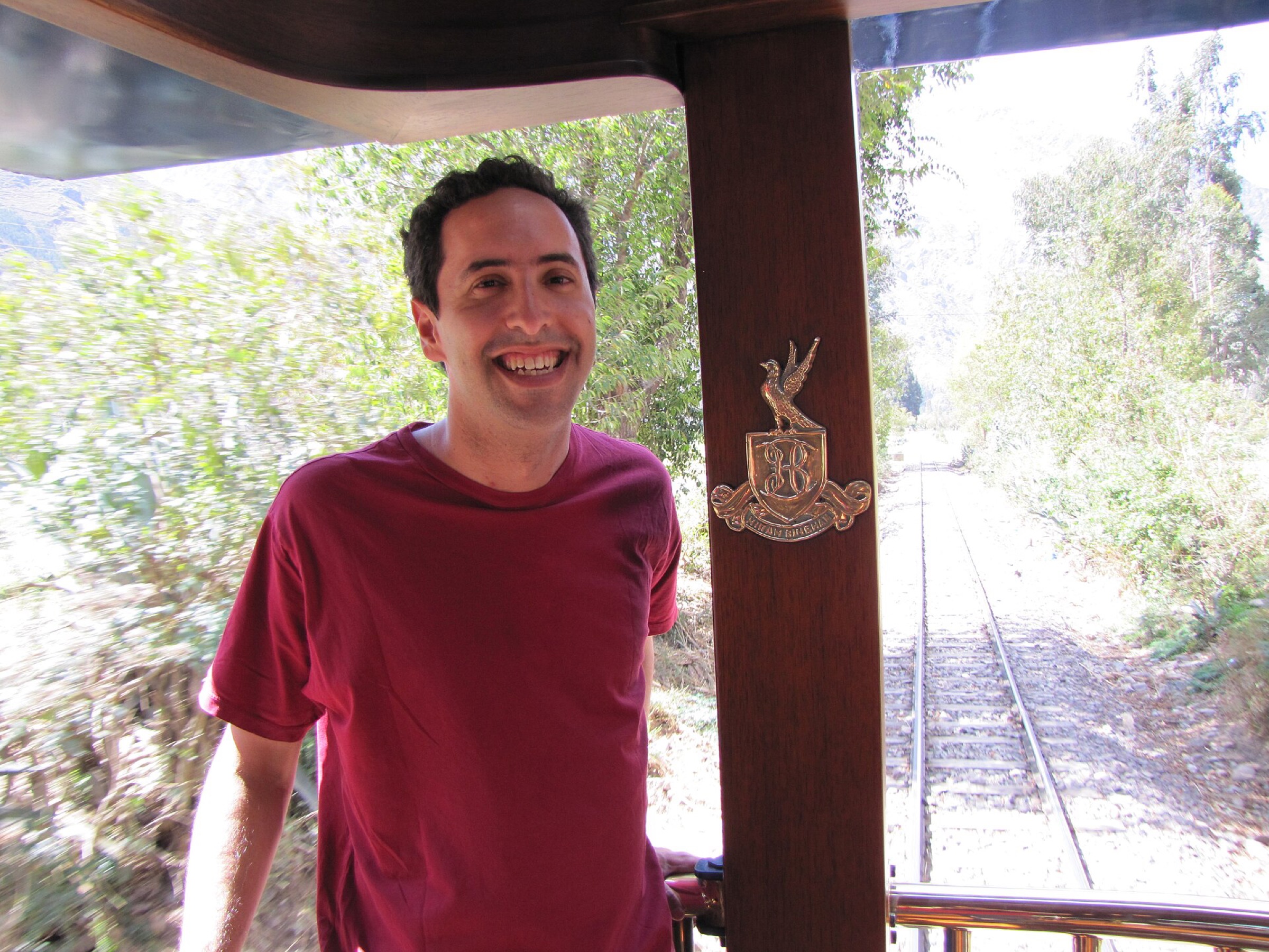 A smiling traveller on the open-air carriage of the train