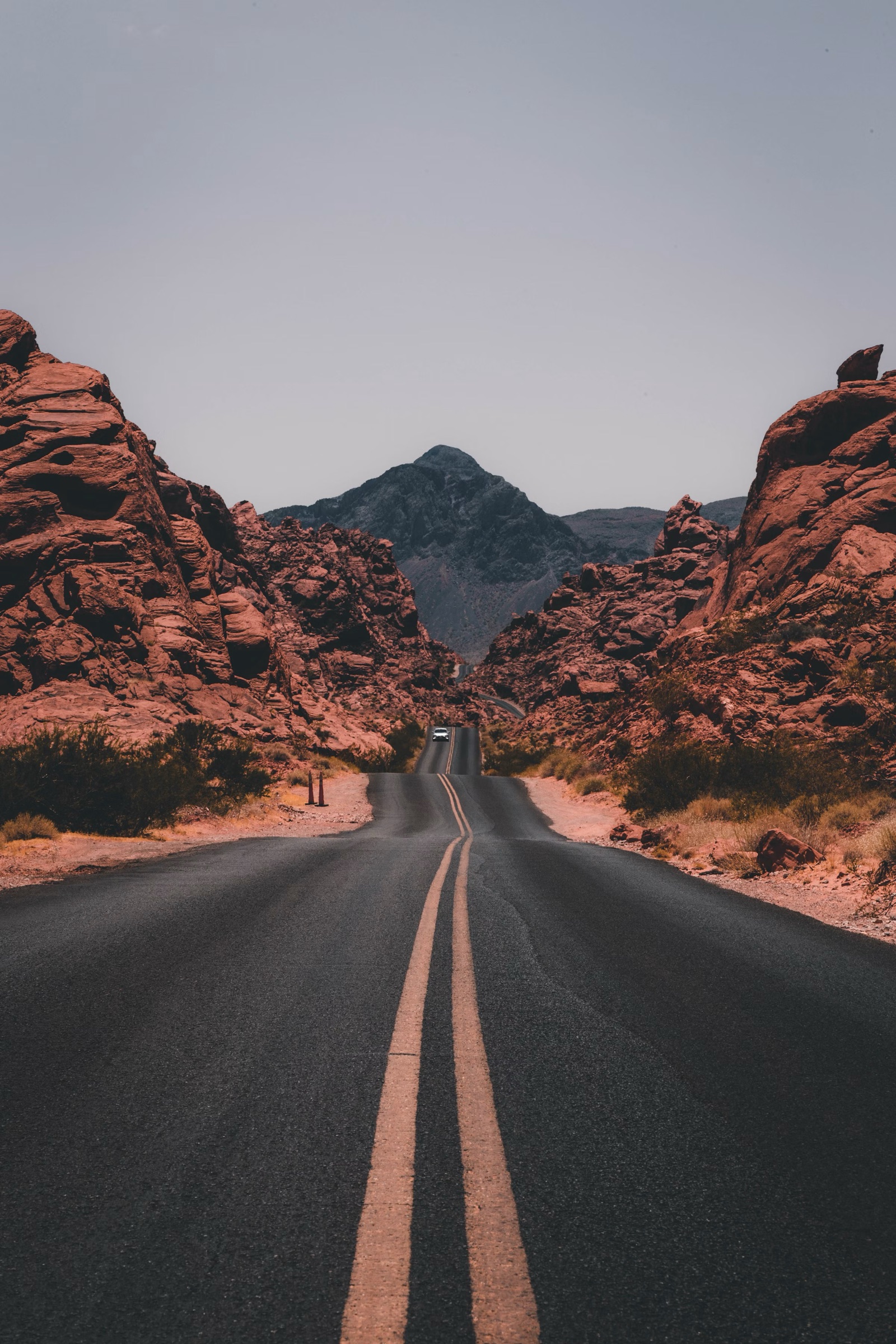 An empty road winding through red rock canyons