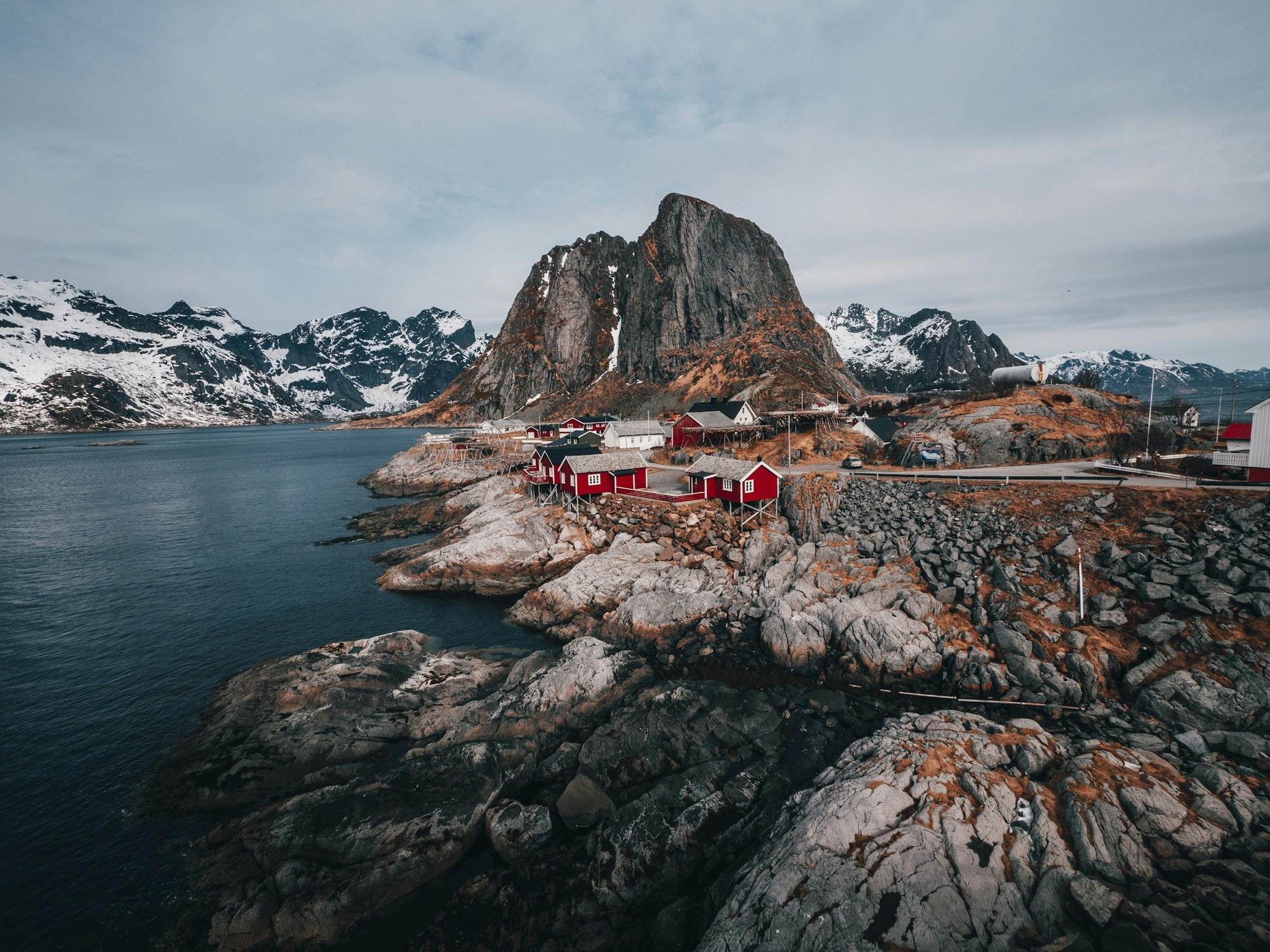 Red fishermen&rsquo;s cabins beneath snowy peaks in the Lofoten Islands